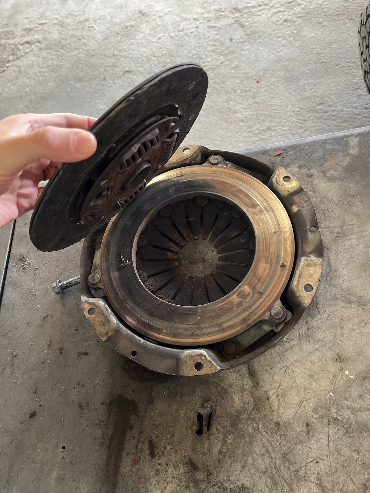 A KC Automotive mechanic with a clutch and pressure plate on the bench
